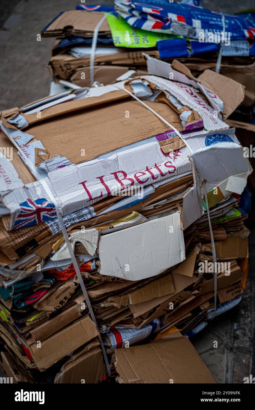 Recycling von Pappschachteln – gebrauchte Pappschachteln flach und gebündelt, bereit für die Sammlung und das Recycling. Stockfoto