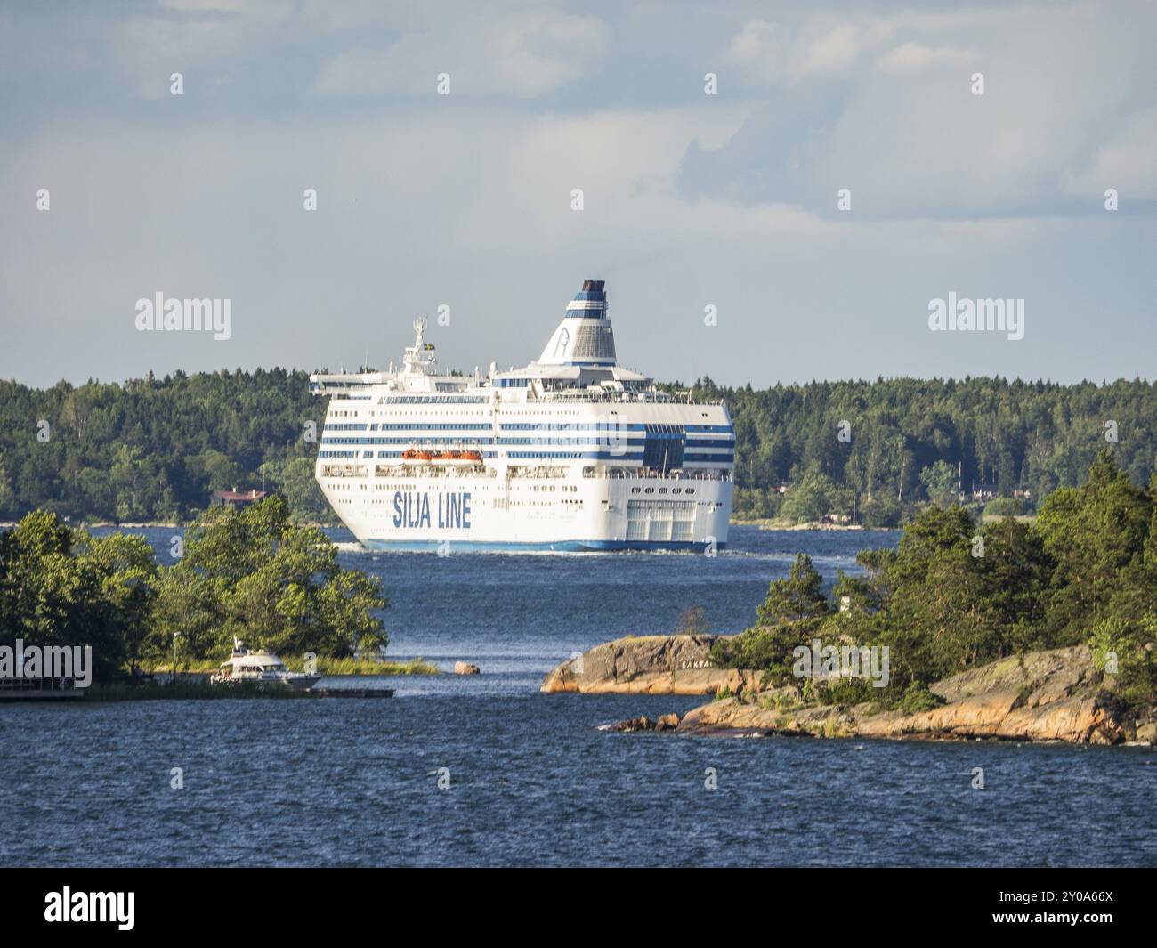 Ein großes Passagierschiff auf einem See, umgeben von Bäumen und leicht bewölktem Himmel, stockholm, ostsee, schweden, skandinavien Stockfoto