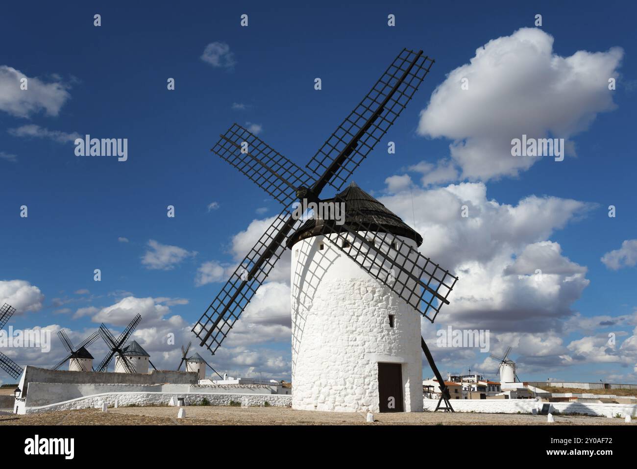 Eine historische weiße Windmühle vor einem blauen Himmel mit Wolken und Sonnenschein in einer weiten Landschaft, Windmühlen, Campo de Criptana, Provinz Ciudad Real, Castill Stockfoto