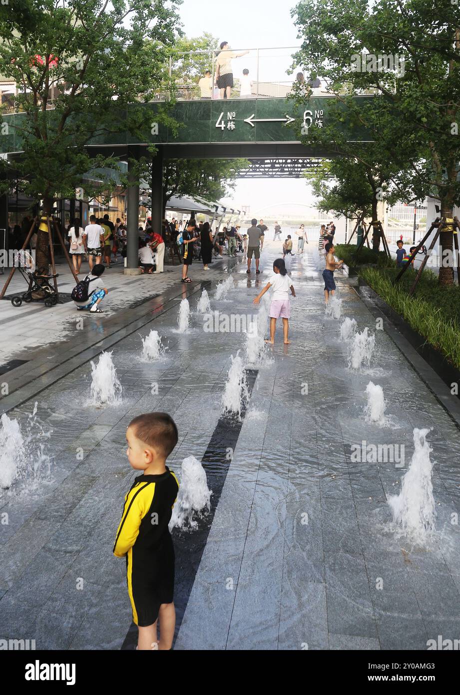 SHANGHAI, CHINA - 1. SEPTEMBER 2024 - Kinder spielen mit Wasser in einem Brunnen, um sich abzukühlen in Shanghai, China, 1. September 2024. Stockfoto