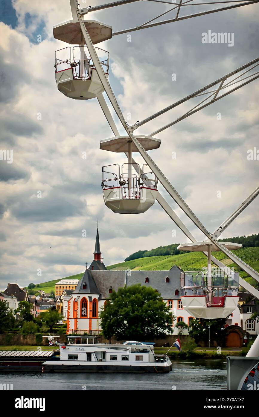 Der Blick über die Mosel zeigt Bernkastel-Kues, wo Gondeln eines großen Riesenrads hoch über der historischen Stadt schweben Stockfoto