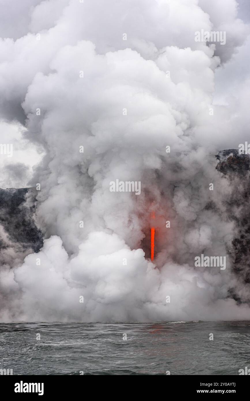 Der Ausbruch des Vulkans Kilauea auf Hawaii bildete eine Lavatür, die aus der Seite einer Klippe kam und in den Ozean mündete. Dies verursachte Explosionen, Dampf, chemische Stoffe Stockfoto