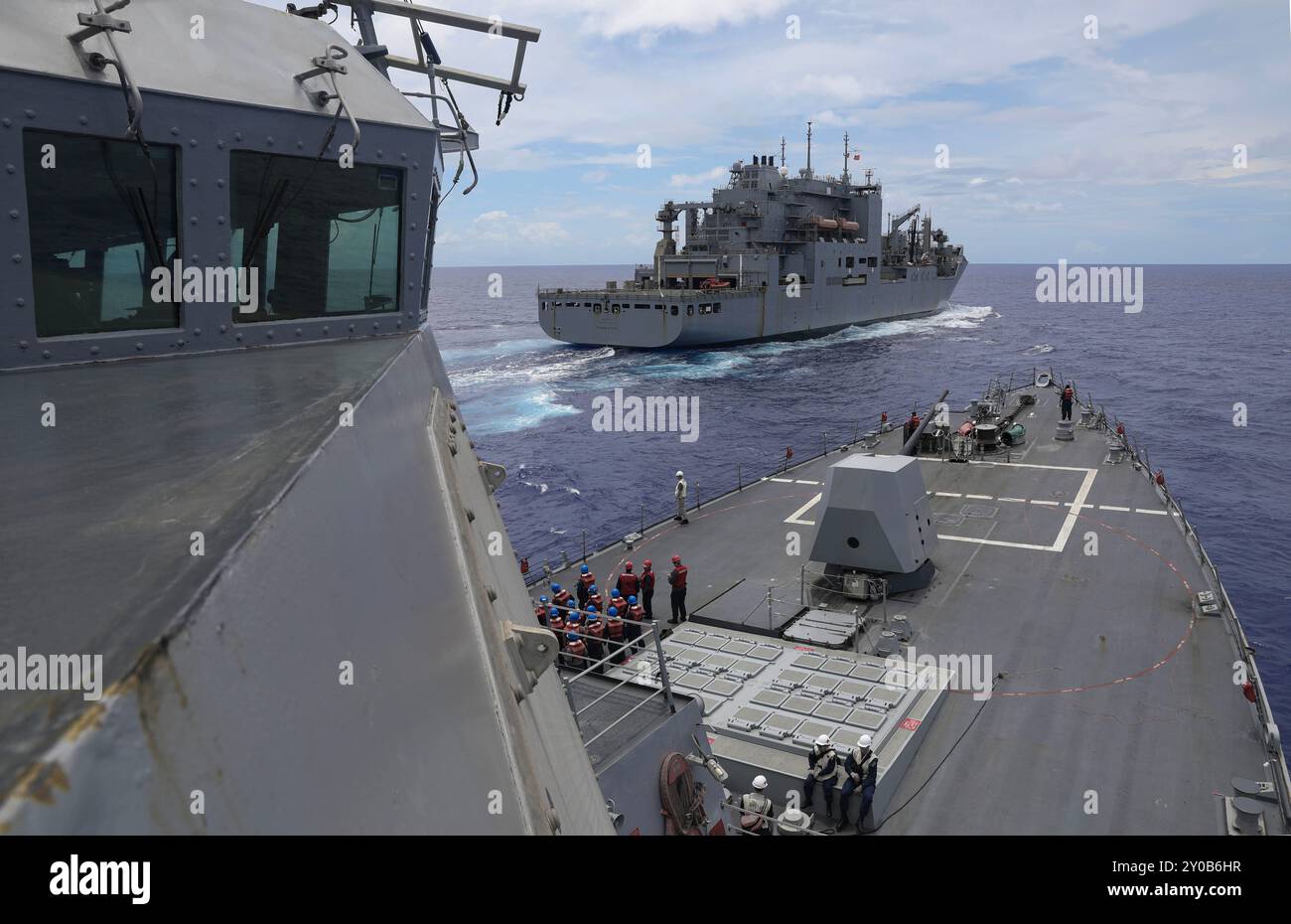 PHILIPPINISCHE SEE (29. August 2024) – der Arleigh-Burke-Klasse-Raketenzerstörer USS Dewey (DDG 105) zieht an der Seite des militärischen Sealift Command Lewis und Clark-Klasse Trockenfrachtschiffs USNS Richard E. Byrd (T-AKE 4), während er während der Übung Pacific Vanguard am 29. August 2024 eine Wiederauffüllung in der Philippinischen See durchführt. Commander, Logistics Group Western Pacific/Task Force 73 versorgt stationierte Einheiten im Indopazifik zusammen mit regionalen Verbündeten und Partnern logistisch neu. Pacific Vanguard ist eine Gelegenheit für gleichgesinnte Kräfte, ihre Fähigkeiten in maritimen Operationen zu stärken, Stockfoto