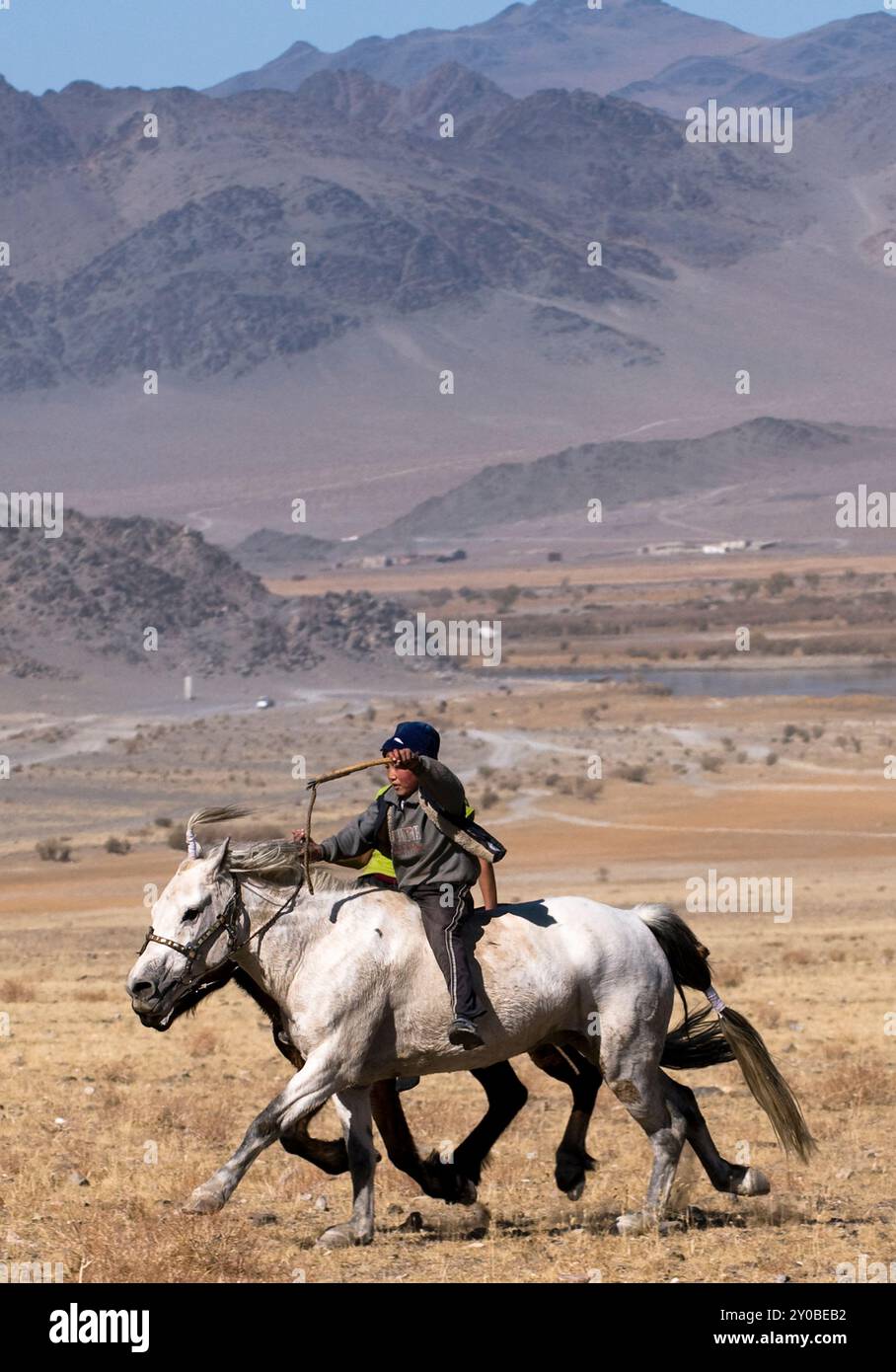 Kasachische Adlerjäger treten beim Tiyn Teru - Münzabholer-Pferderennen in der Region Altai in der Westmongolei an. Stockfoto