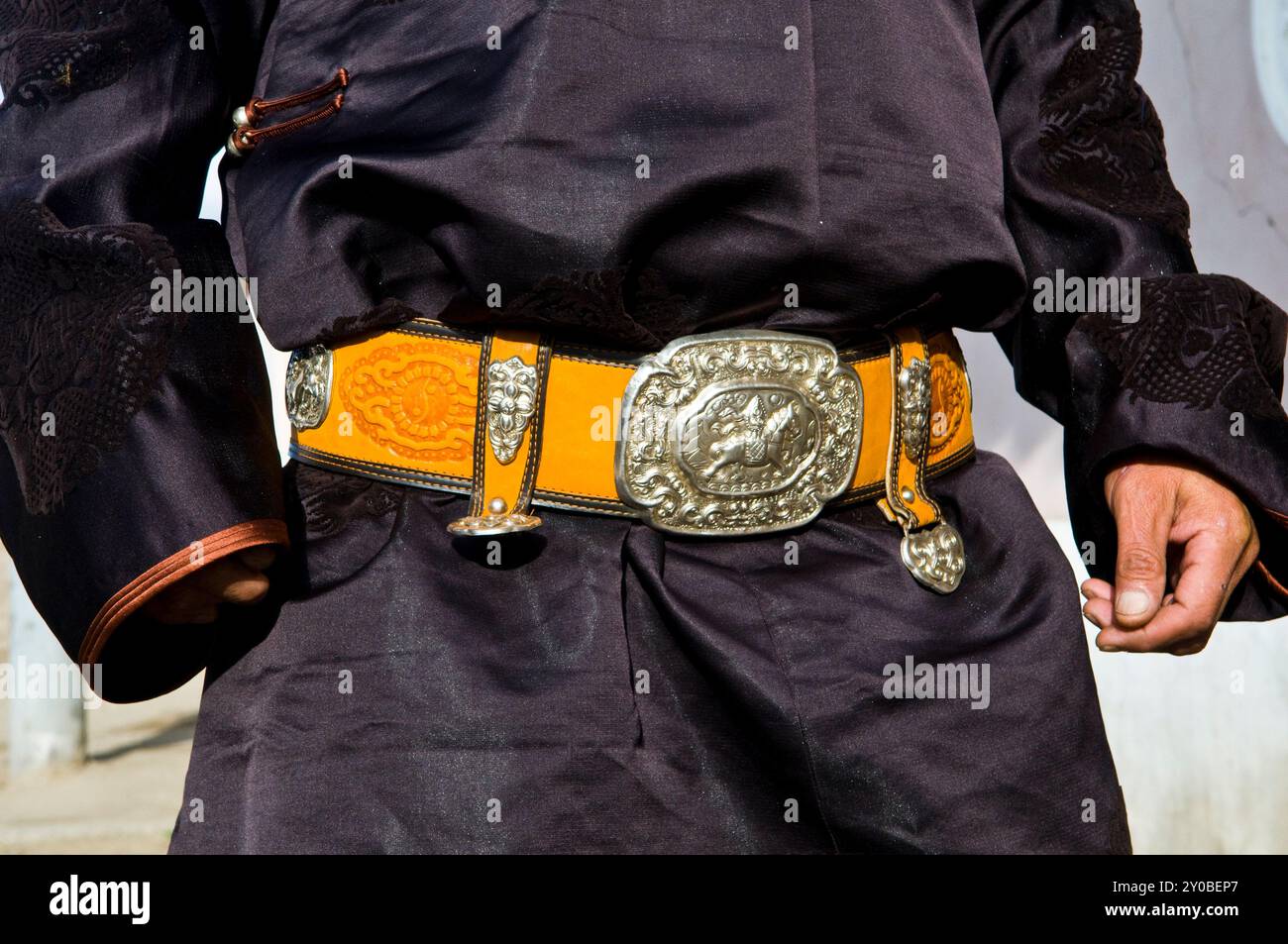 Ein mongolischer Mann, der einen bunten Gürtel trägt. Foto gemacht in Charkhorin, Mongolei. Stockfoto