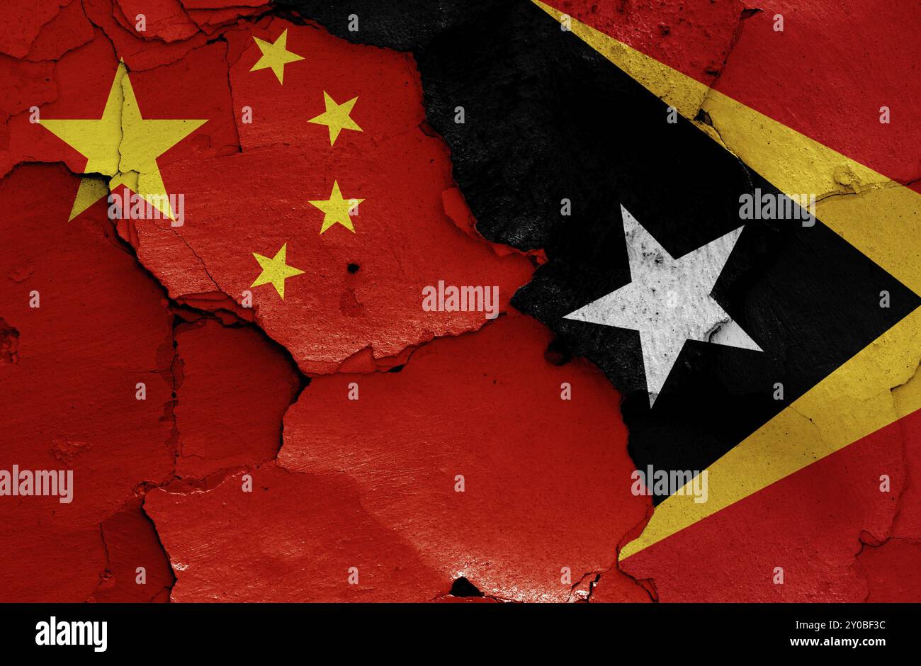 Flaggen von China und Osttimor auf rissige Wand gemalt Stockfoto
