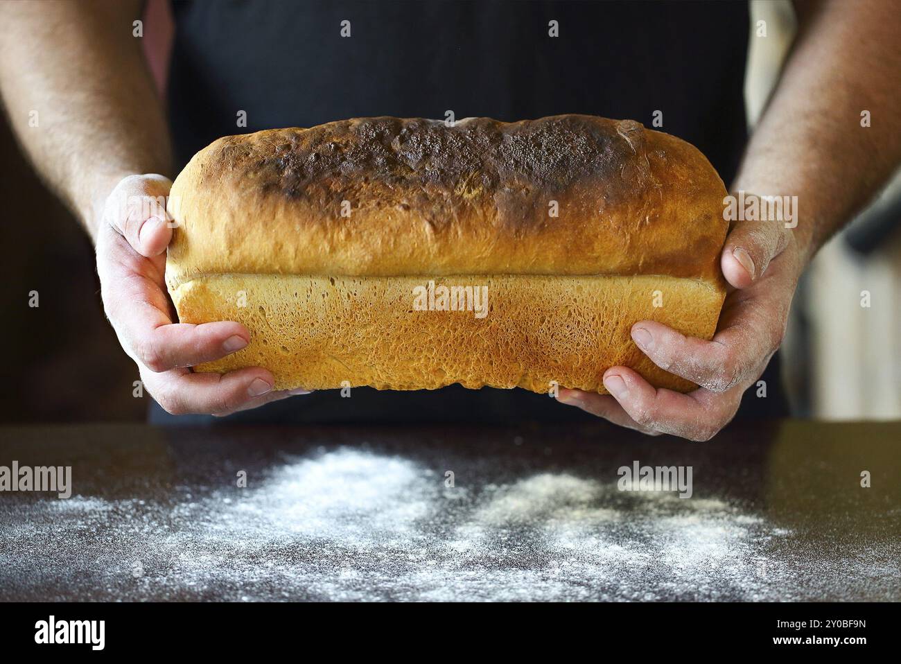 Männliche Hände halten frisch gebackenes Brot, in der Nähe Stockfoto