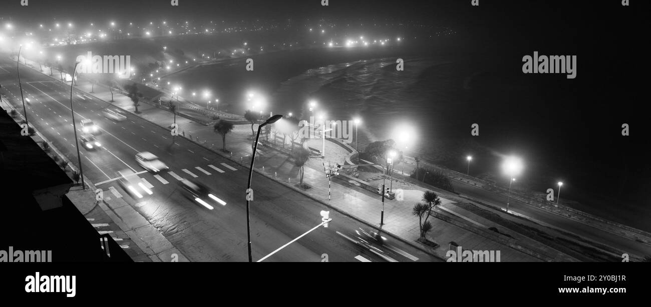 Blick von oben auf die Straße mit Verkehr in der Stadt bei Nacht in Schwarz-weiß Stockfoto