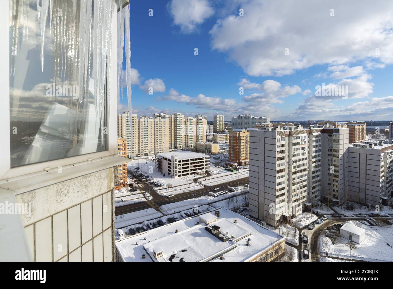 Große Eiszapfen hängen auf dem Balkon eines Hauses in der Stadt Stockfoto