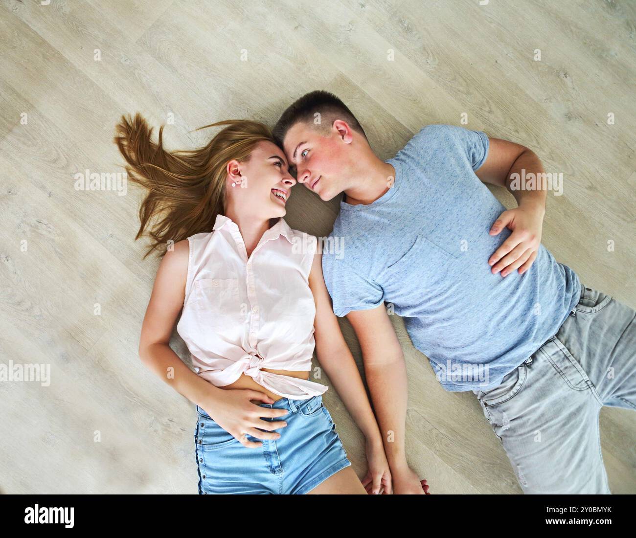 Glückliches junges Paar zu Hause entspannt auf dem Boden Stockfoto