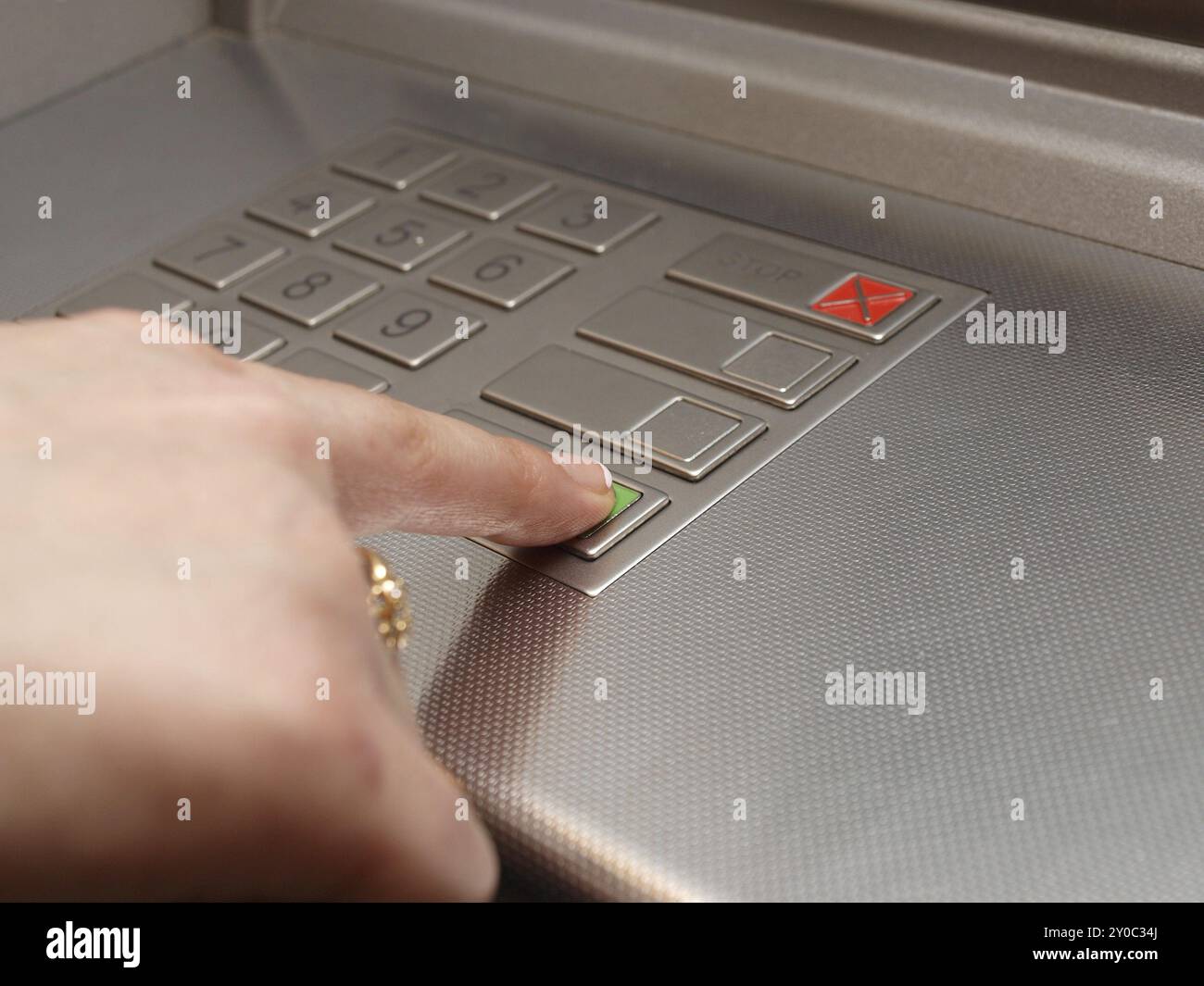 Der Geldautomat wählt, jemand drückt die OK-Taste Stockfoto