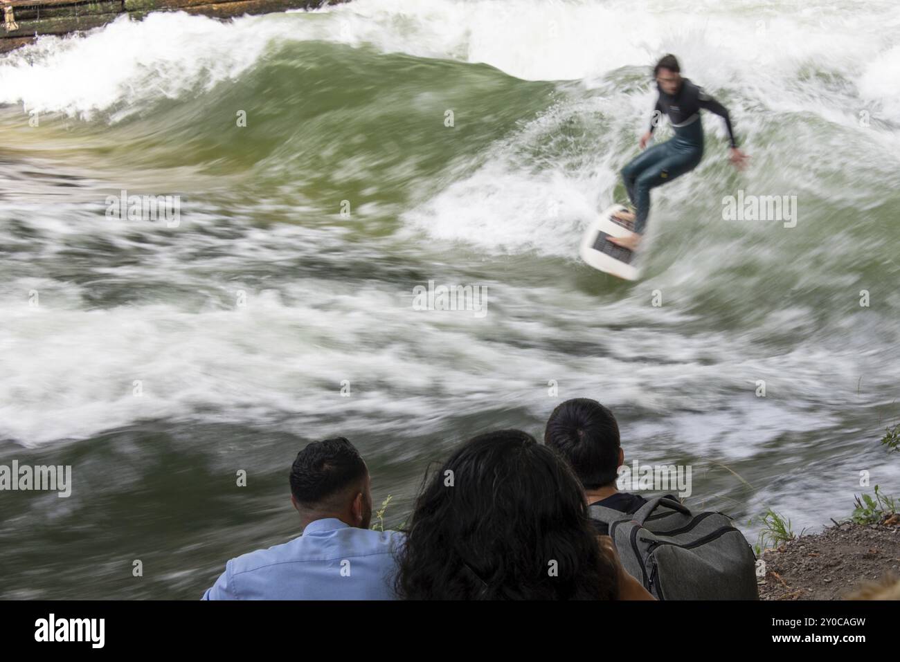 Surferfahrten Eisbachwelle, Zuschauer am Ufer, Eisbach und Wave im Englischen Garten sind weltweit bekannt, München, Bayern, Deutschland, Europa Stockfoto