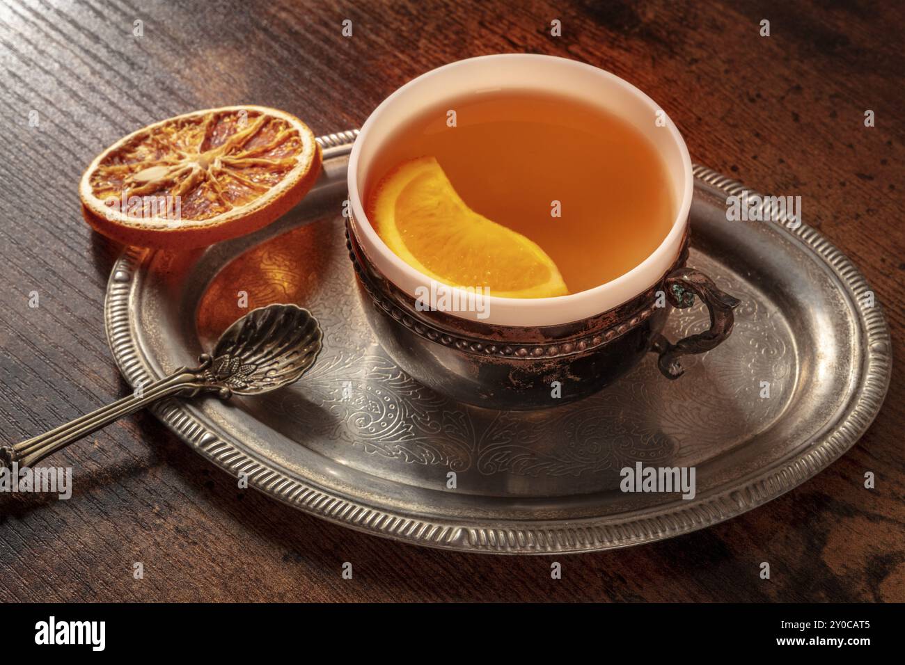 Orangentee mit frischen und getrockneten Orangen auf einem Vintage-Tablett, eine Tasse auf einem dunklen rustikalen hölzernen Hintergrund, Lebensmittelfotografie Stockfoto