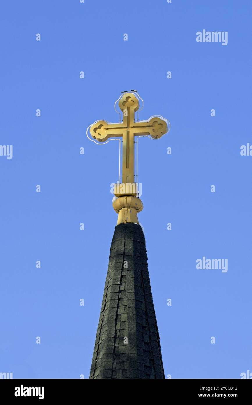 Ein Konzeptfoto eines Kreuzes an der Spitze eines Turms vor einem blauen Himmel in Nord-Idaho Stockfoto