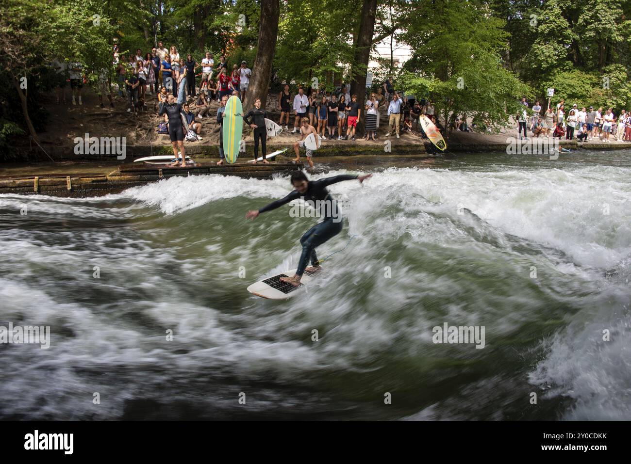 Surfer im Eisbach, zahlreiche Zuschauer am Ufer, Eisbachwelle im Englischen Garten ist weltweit bekannt, München, Bayern, Deutschland, Europa Stockfoto