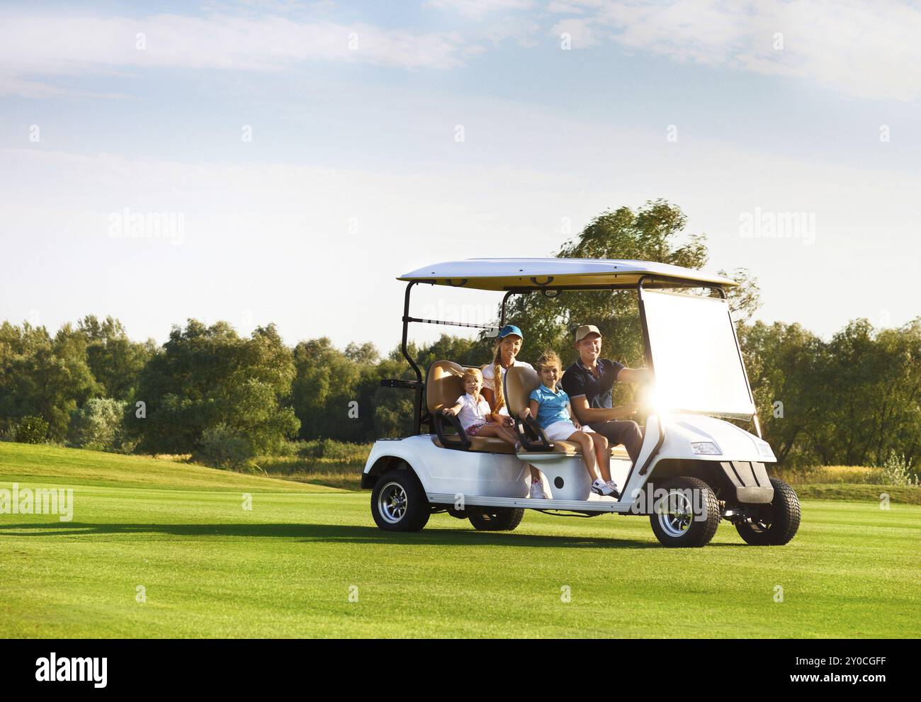 Schöne glückliche Familienbild in einem Wagen auf dem Golfplatz Stockfoto