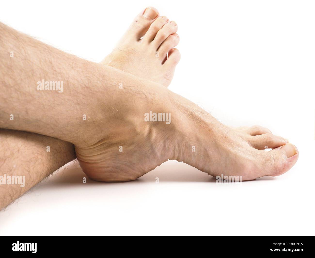 Behaarte Beine und Füße eines männlichen Menschen, der auf weißem Hintergrund ruht Stockfoto