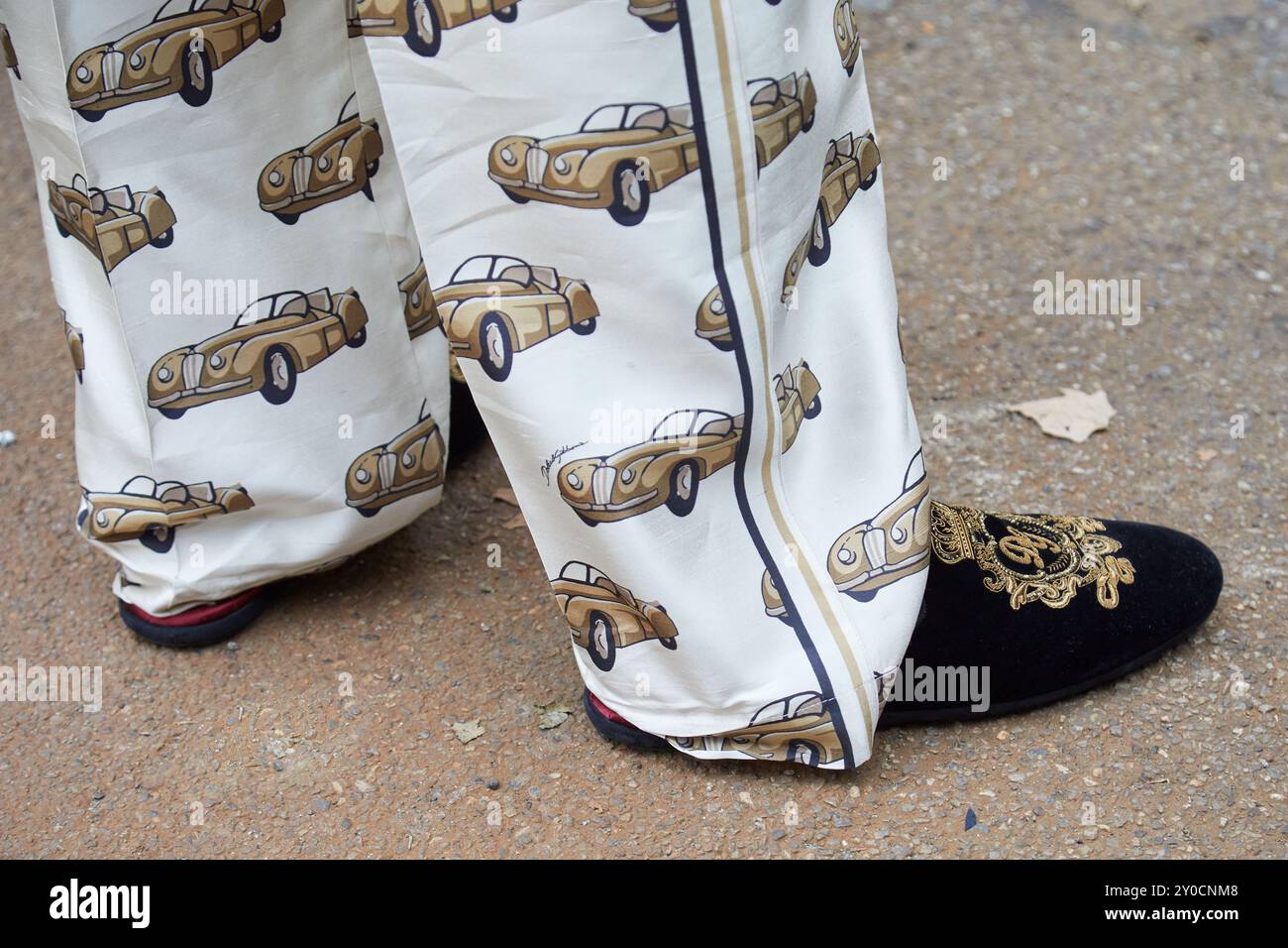 MAILAND, ITALIEN - 15. JUNI 2024: Mann mit Dolce und Gabbana schwarzen Samtschuhen mit goldenem Wappen vor der Dolce and Gabbana Modenschau, Milan Fashion We Stockfoto