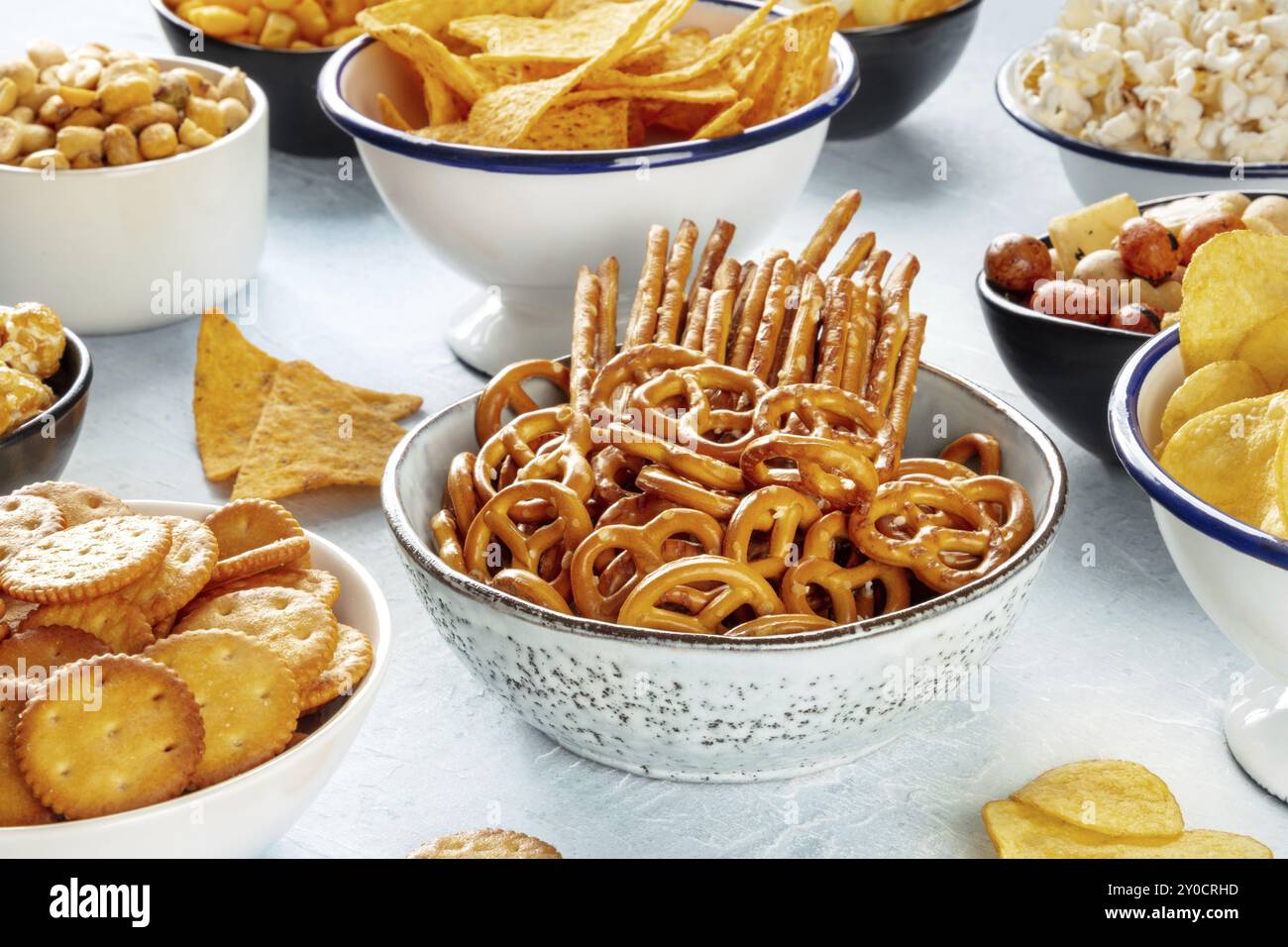 Salzige Snacks, Partymix, eine Auswahl knuspriger Vorspeisen in Schüsseln auf einem Tisch. Cracker, Sticks usw., Lebensmittelfotografie Stockfoto