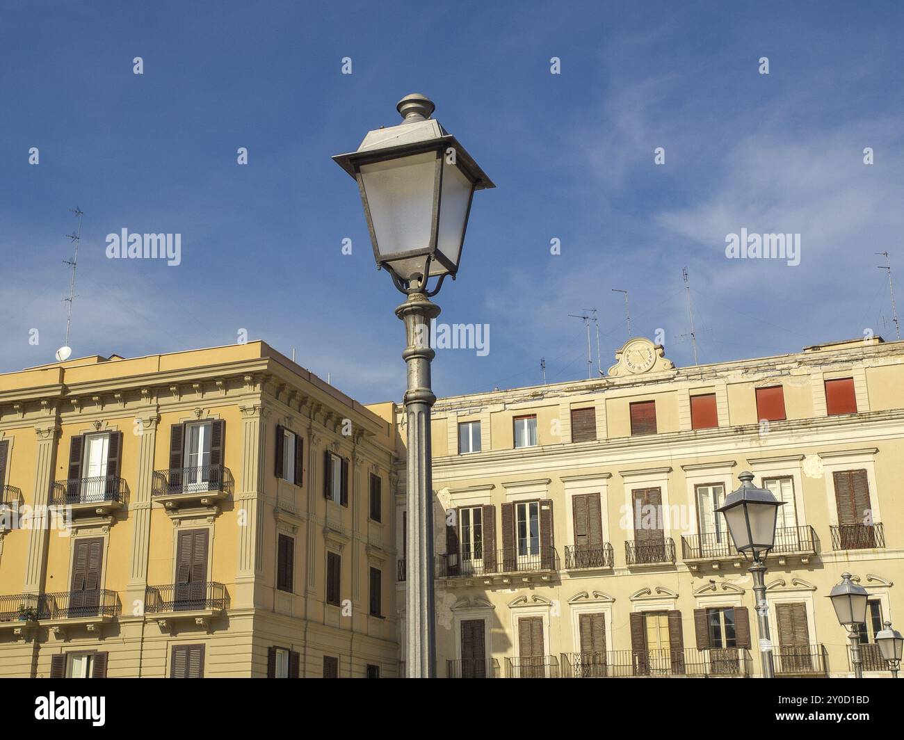Historisches Gebäude in hellem Sonnenschein mit Straßenlaterne vor einem hellblauen Himmel, Bari, Mittelmeer, Italien, Europa Stockfoto