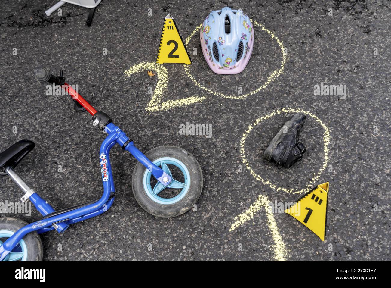 Markierungen an einem Unfallort mit Kinderwaagerad, Helm, nachgeahmter Unfallaufzeichnung, bei einer öffentlichen Veranstaltung der Kölner Polizistin Stockfoto