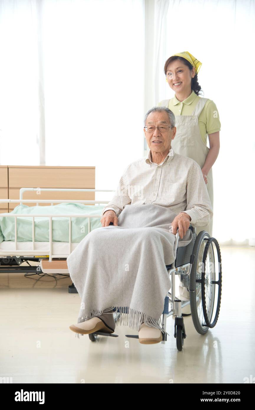 Pflegehelfer und alter Mann im Rollstuhl Stockfoto