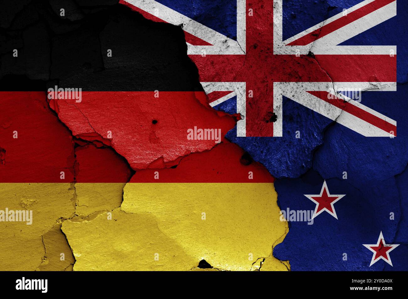 Flaggen von Deutschland und Neuseeland auf gerissene Wand gemalt Stockfoto