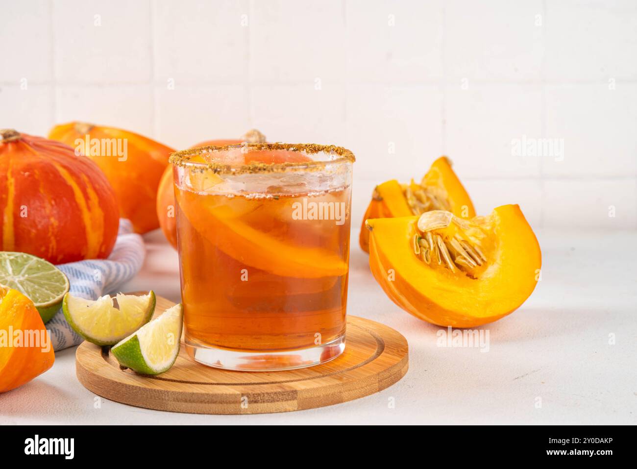 Thanksgiving Margarita, Süßer Kürbis Sträucher Cocktail, Alkohol leckeres Herbstgetränk auf weißem Hintergrund mit Scheiben Kürbisse, Kopierraum Stockfoto