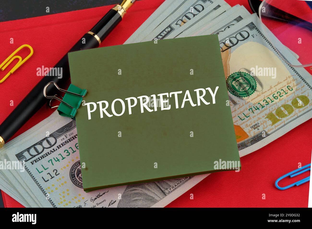 Buchstaben des Alphabets mit den EIGENEN Wörtern auf einem grünen Aufkleber auf dem Hintergrund von Dollarscheine auf dem roten Buch Stockfoto