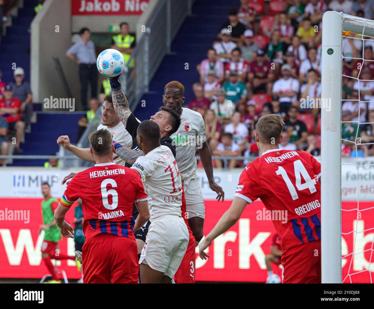 Kevin Müller (Torwart 1. FC Heidenheim) faustet den Ball weg vor Keven Schlotterbeck (FC Augsburg #31), Steve Mounié (FC Augsburg) und Samuel Essende (FC Augsburg #9, hinten), Leonardo Scienza (1. FC Heidenheim #6), Maximilian Breunig (1. FC Heidenheim #14); FC Augsburg vs. FC Heidenheim, 2. SPIELTAG; DFL-VORSCHRIFTEN VERBIETEN DIE VERWENDUNG VON FOTOS ALS BILDSEQUENZEN UND/ODER QUASI-VIDEO. Stockfoto