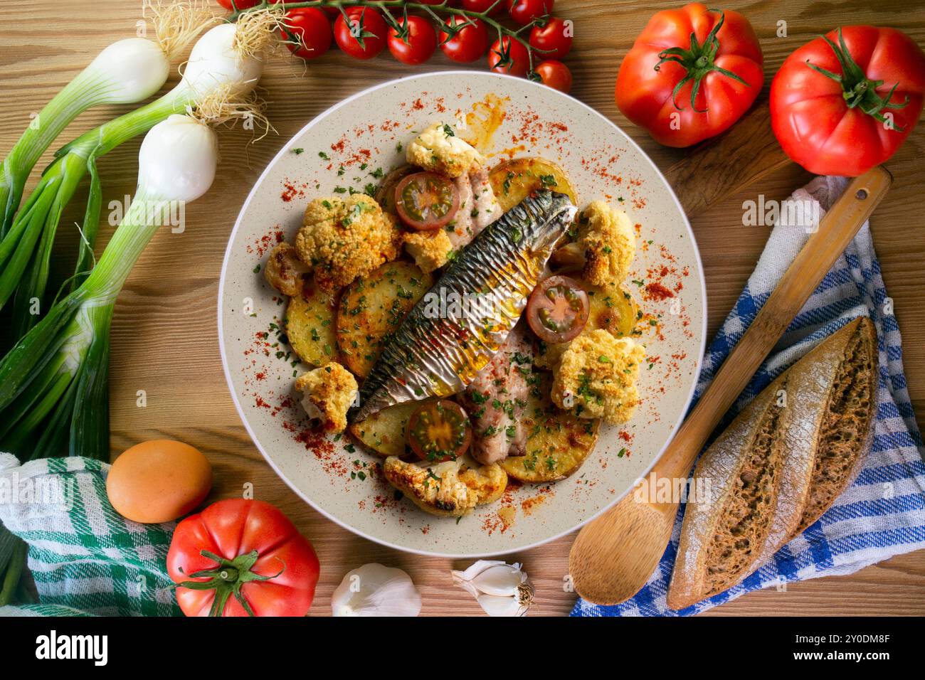 Gebackene Makrele mit geschmortem Blumenkohl und Kirschtomaten. Tabelle mit Draufsicht. Stockfoto