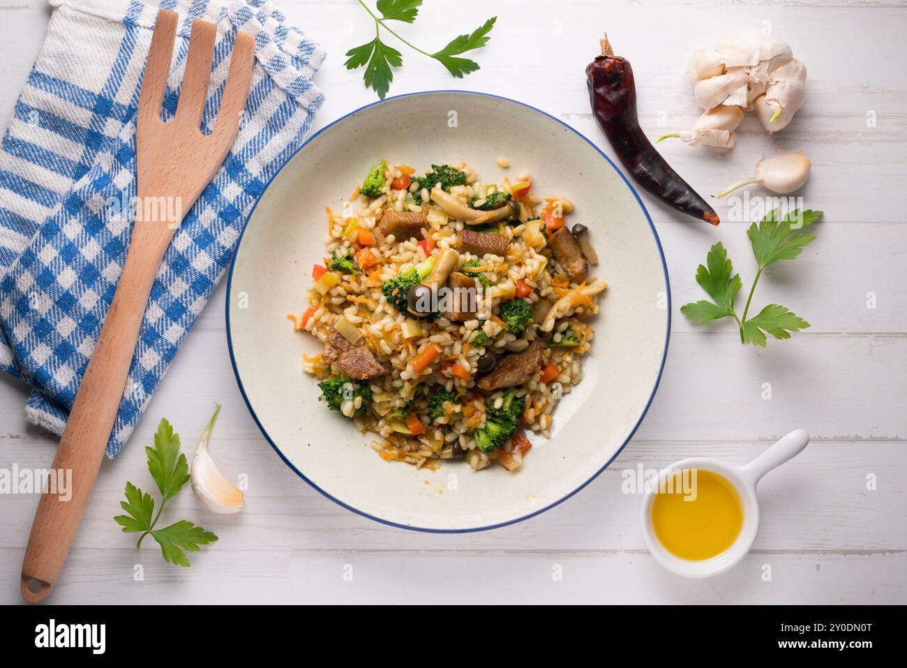 Reispaella mit Schweinelende, Pilzen und Brokkoli. Tisch mit Panoramablick und weihnachtsdekoration. Stockfoto