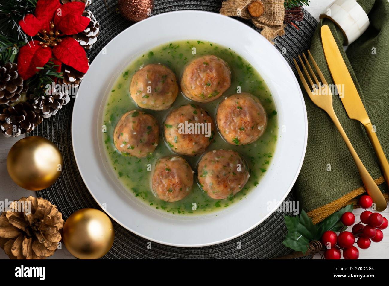 Fischfleischbällchen mit grüner Petersiliensauce. Tisch mit Panoramablick und Weihnachtsdekoration. Stockfoto