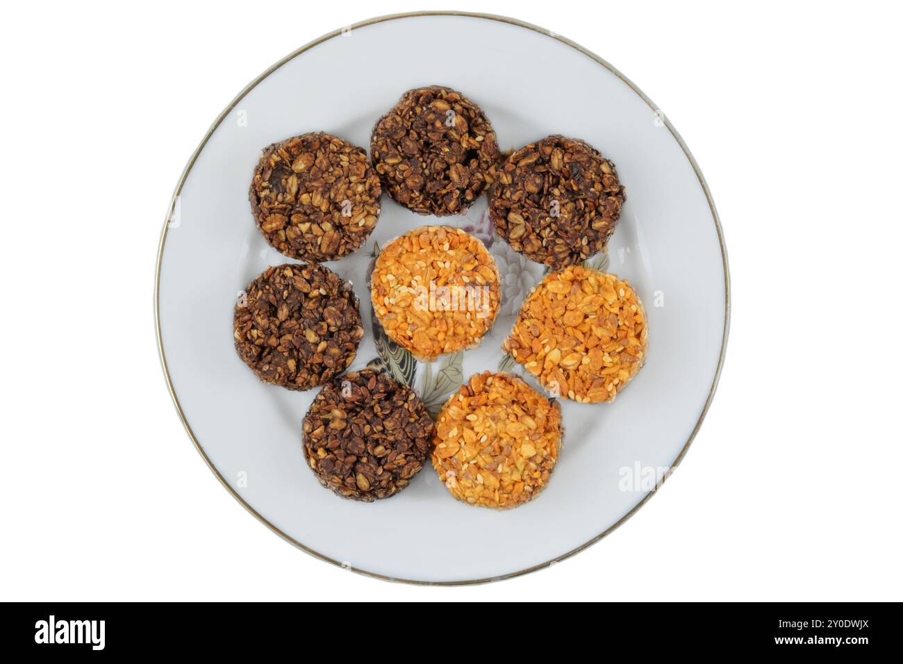 Verschiedene Kuchen in Keramikplatte isoliert auf weißem Hintergrund. Gelbe und braune romantische Kekse. Draufsicht. Stockfoto