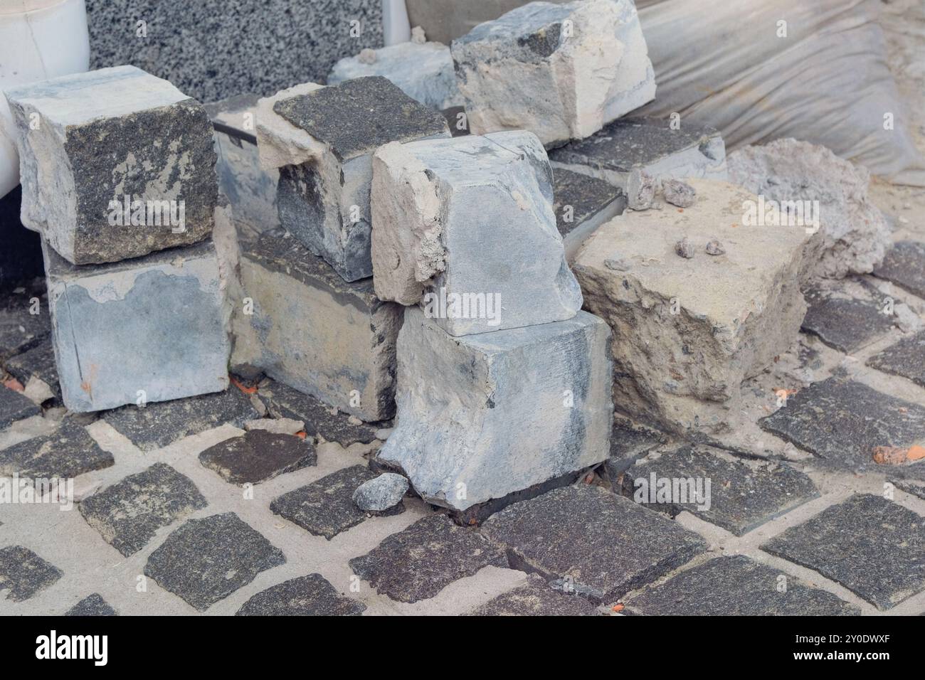 Kopfsteinpflaster werden auf der Straße gelegt. Straßenreparatur in der Stadt. Graue Steine zur Reparatur. Neuer Bürgersteig. Stockfoto