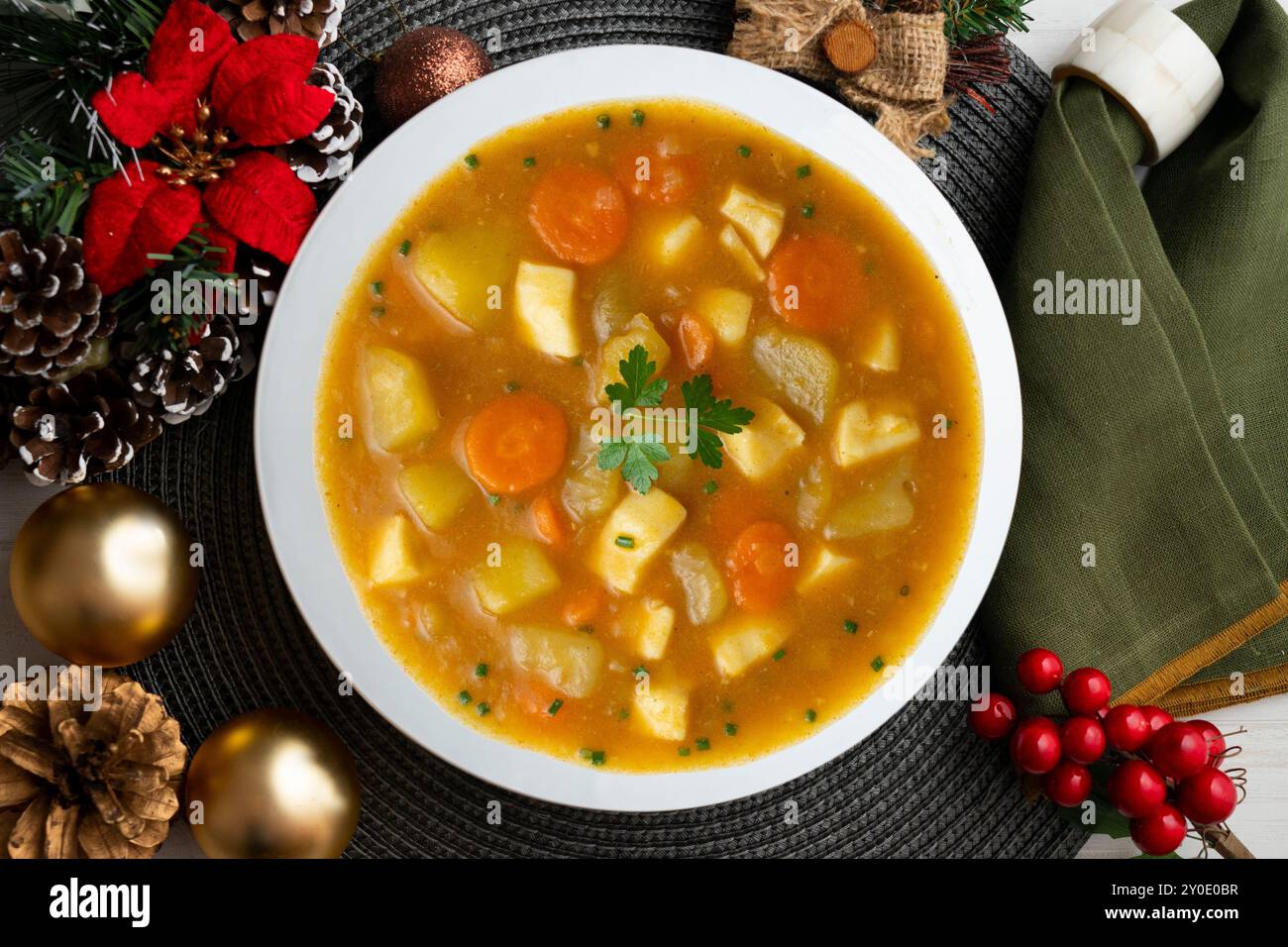 Tintenfisch-Eintopf mit Kartoffeln und Gemüse. Tisch mit Panoramablick und Weihnachtsdekoration. Stockfoto