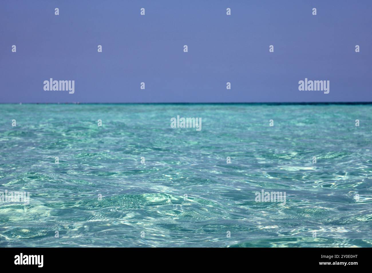 Leerer Strand, Blick auf azurblaue Wasseroberfläche und blauen Himmel Stockfoto