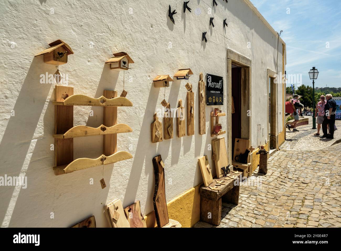 Kaufen Sie mit Holzgegenständen in Óbidos, einer ummauerten portugiesischen Stadt, einem Touristenziel in der Region Lissabon. Charmante und attraktive Stadt in Portugal. Stockfoto