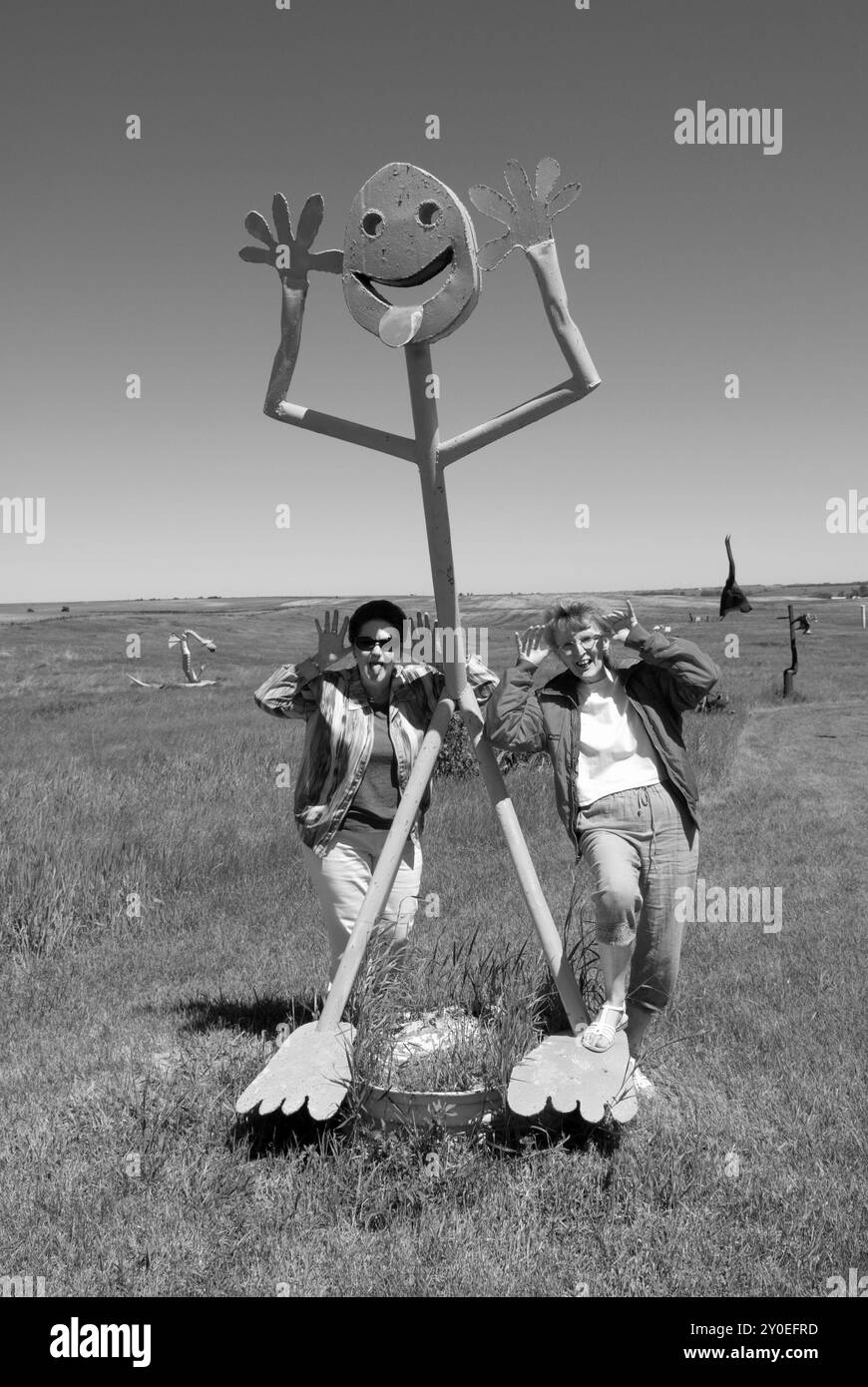 Zwei kaukasische Frauen im Alter von 55 bis 60 Jahren genießen und sehen eine Statue im Porter Sculpture Park in Montrose, South Dakota. Stockfoto