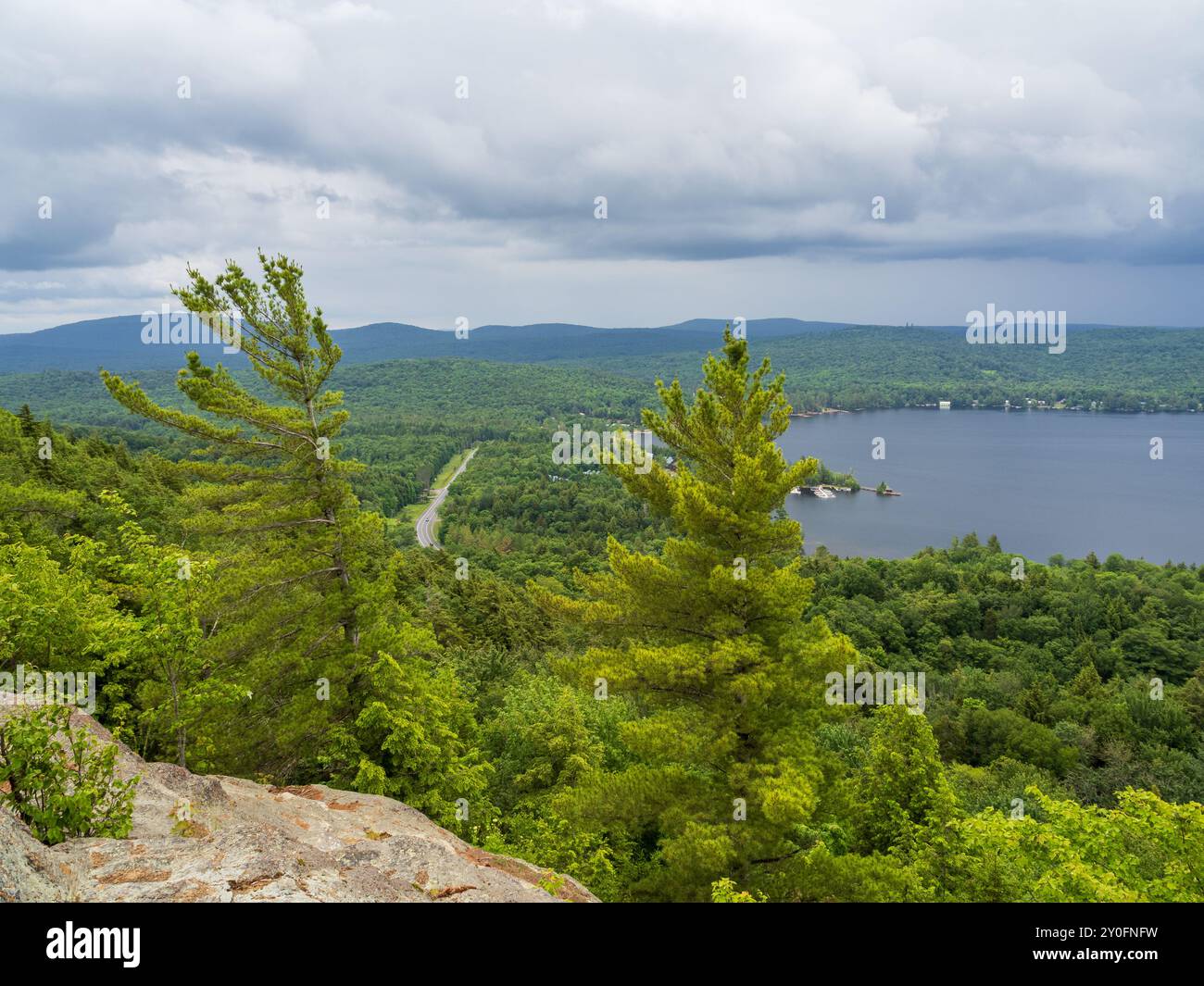 Bestaunen Sie die atemberaubende Ostseite des Fourth Lake vom Gipfel des Rocky Mountain Trail, mit der Route 28, die sich durch die atemberaubende Adironda schlängelt Stockfoto