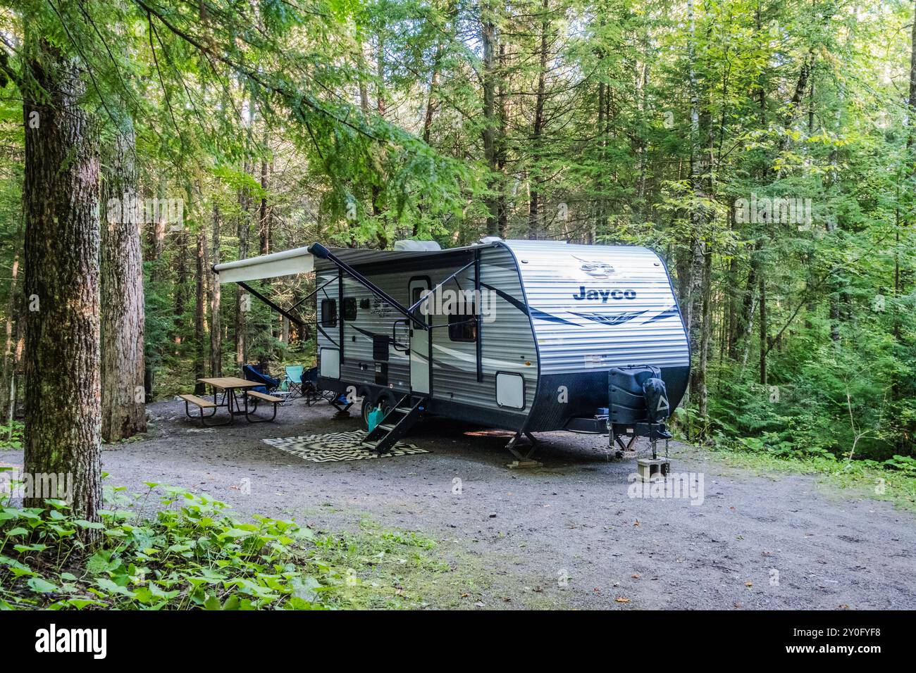 Jayco Reisekoffer parkt auf einem Campingplatz und bietet eine typische Einrichtung mit Campingausrüstung und natürlicher Umgebung für einen komfortablen Aufenthalt im Freien. Stockfoto