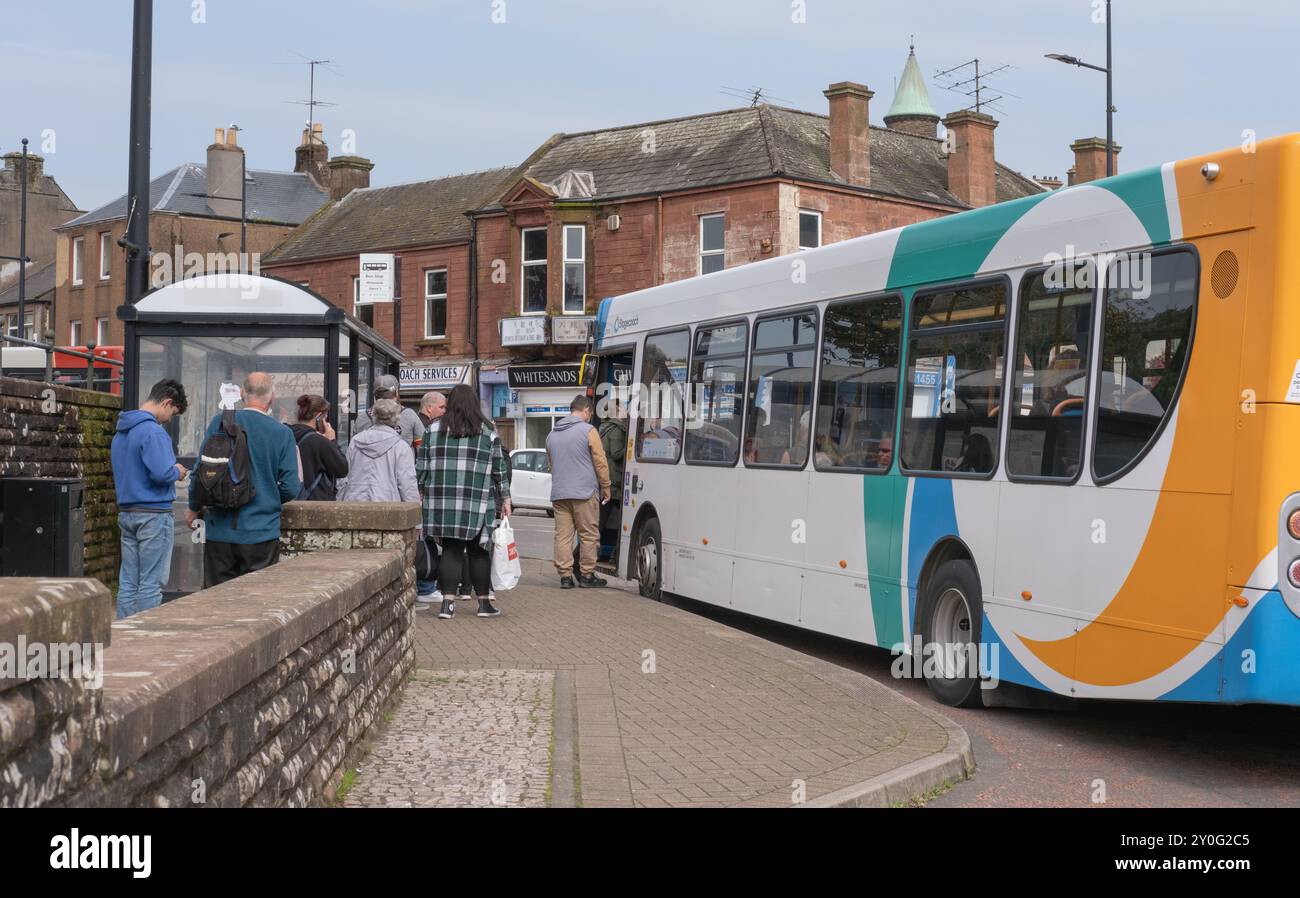 Die Leute stehen neben einer Bushaltestelle an, um in einen Stagecoach-Eindeckerbus zu steigen, der im Whitesands, Dumfries Stadtzentrum, Schottland, liegt. Stockfoto