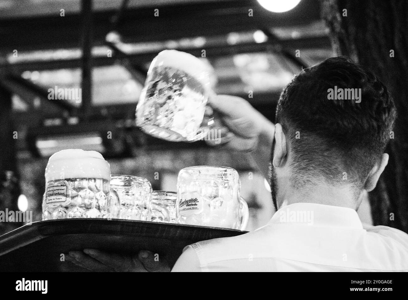 Ein Kellner serviert Bier in einem traditionellen österreichischen Biergarten Stockfoto