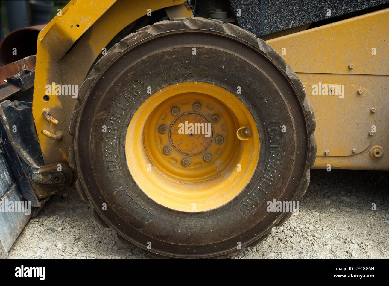 Detail des Vorderrads eines Straßenfahrzeugs auf einer Schotteroberfläche. Stockfoto