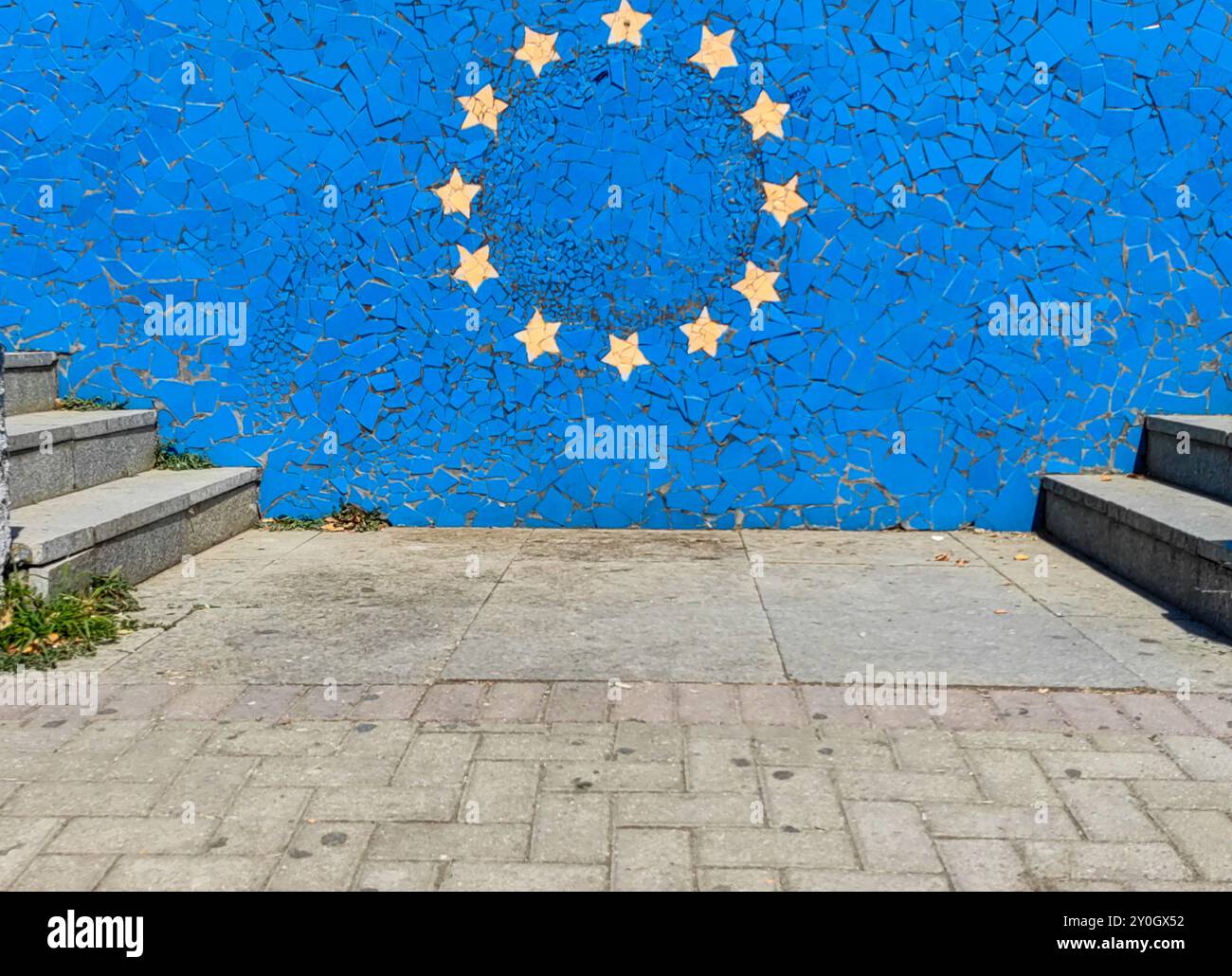 Zwölf goldene Sterne auf einer blauen Betonmauer – Symbol der europäischen Einheit. Rahmen durch Betontreppen. Mazedonien 2024 Stockfoto