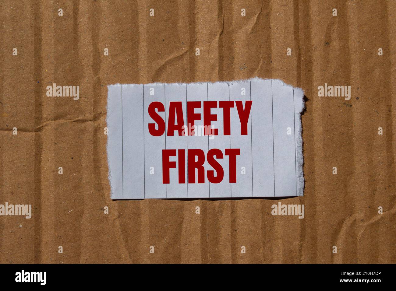 Sicherheitshinweis auf zerrissenem Papier mit Papphintergrund. Symbol für konzeptionelle Sicherheit an erster Stelle. Kopierbereich. Stockfoto