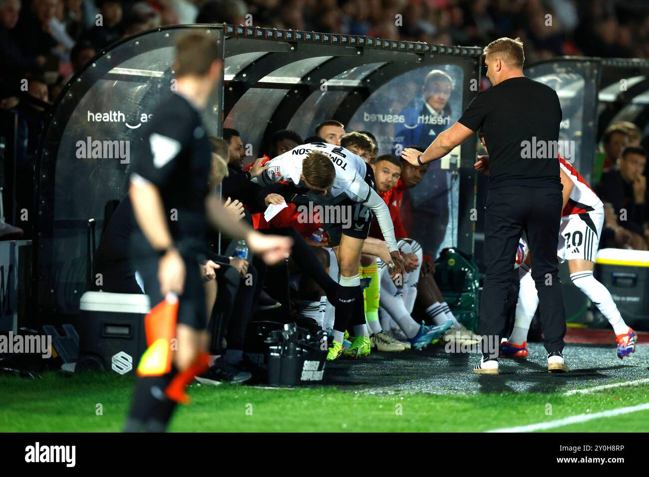 Joe Tomlinson (Mitte) von Milton Keynes Dons stößt beim Spiel der Sky Bet League Two im Peninsula Stadium in Salford auf das Dugout von Salford City. Bilddatum: Montag, 2. September 2024. Stockfoto