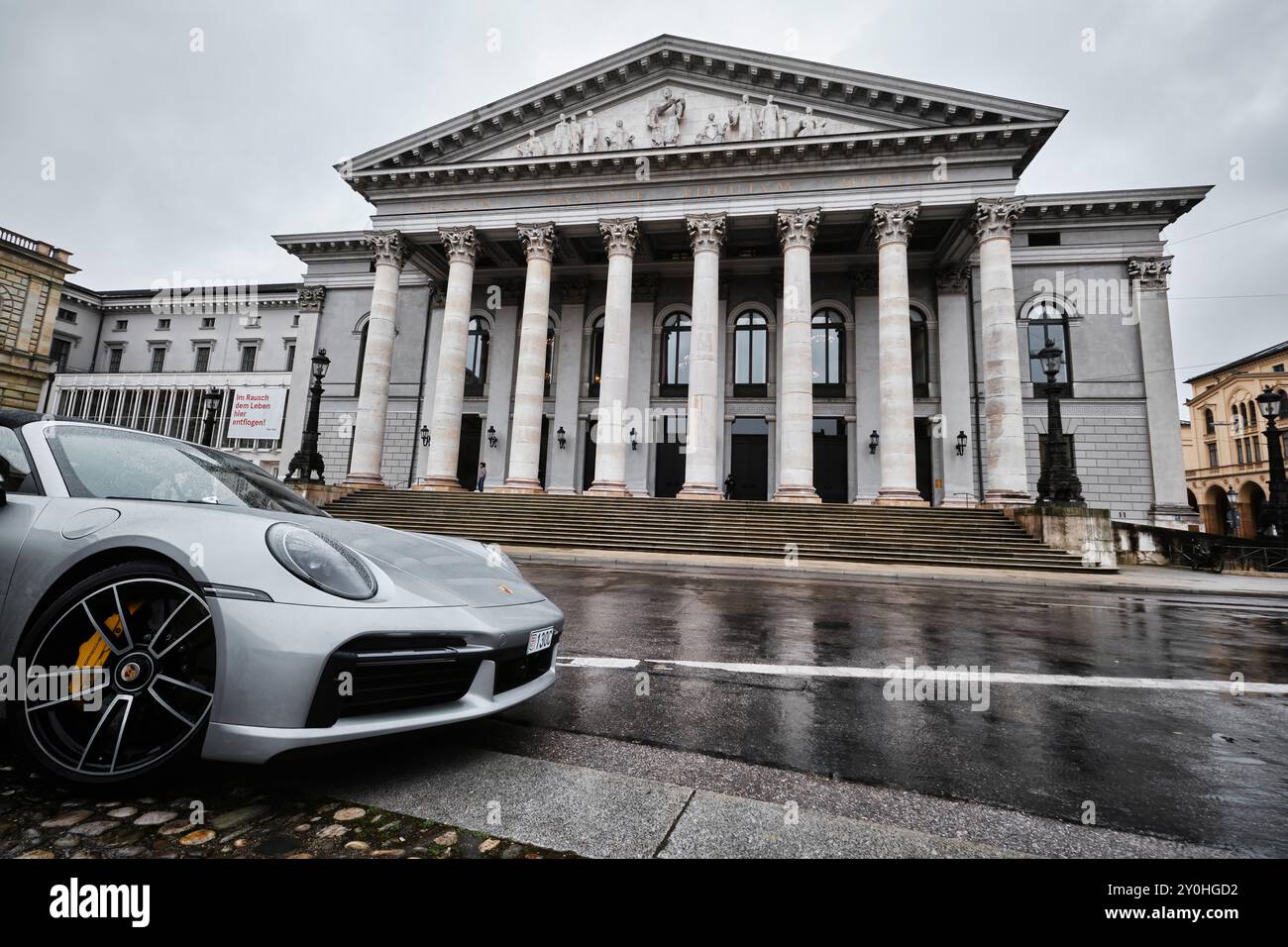 München – 17. April 2024: Münchner Nationaltheater oder Nationaltheater auf dem Max-Joseph-Platz. Heimat der Bayerischen Staatsoper mit einem porsche 911 Stockfoto