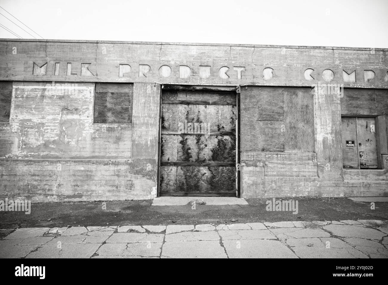 Ein verlassenes Industriegebäude mit Art-Deco-Schriftzug auf der Vorderseite. Ellensburg WA, USA. Schwarzweißbild. Stockfoto