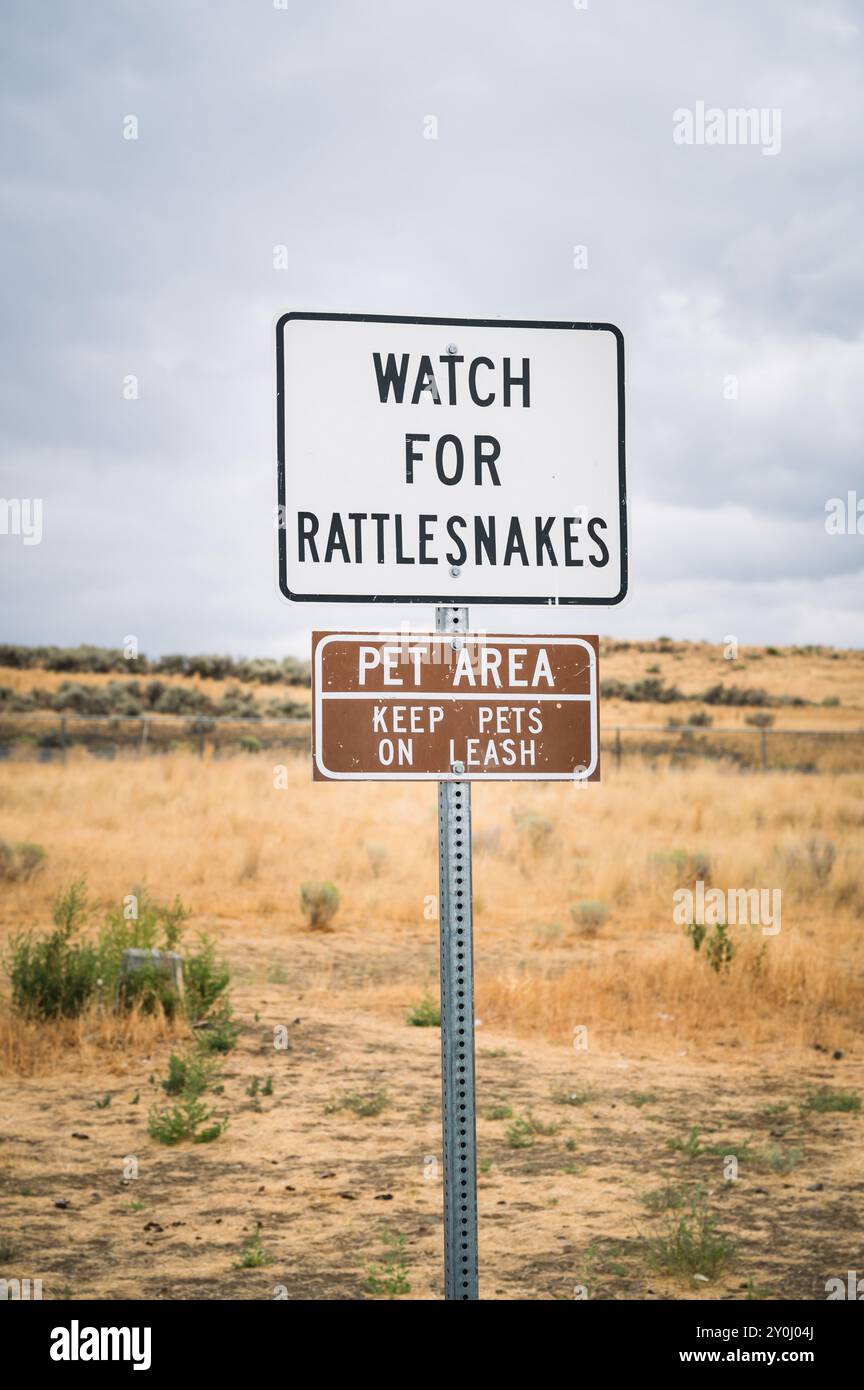Ein Schild für Klapperschlangen in der Nähe einer Haltestelle des Washington State Highway. Stockfoto